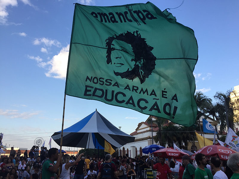 A flag from the popular education movement Emancipa states, “Education is our weapon!” It depicts the face of Marielle Franco, a city councilwoman and former popular educator in Rio de Janeiro assassinated in 2018. (Photo by Alice Taylor.)