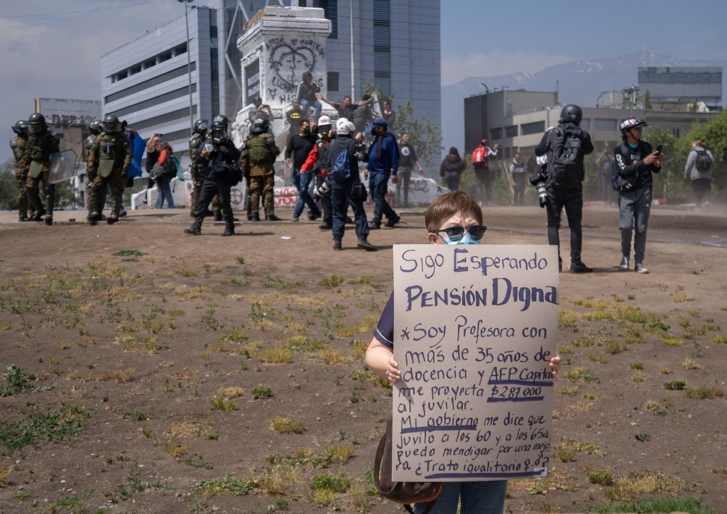 Child protesting with Sign, and armed military behind them