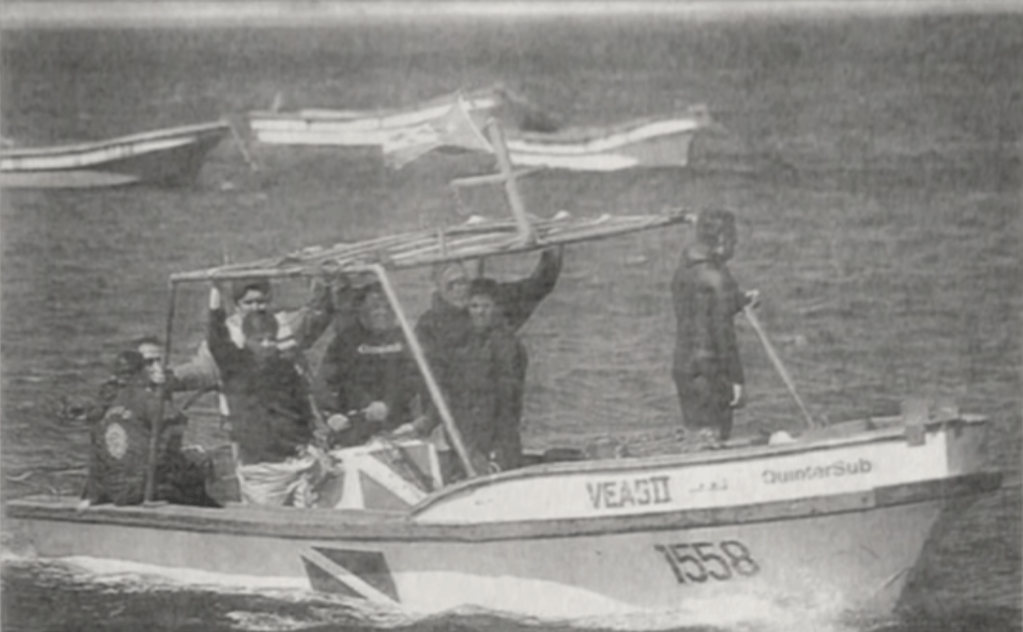 Judge Juan Guzmán Tapia and detectives return to shore after search for rails on Quintero Bay.