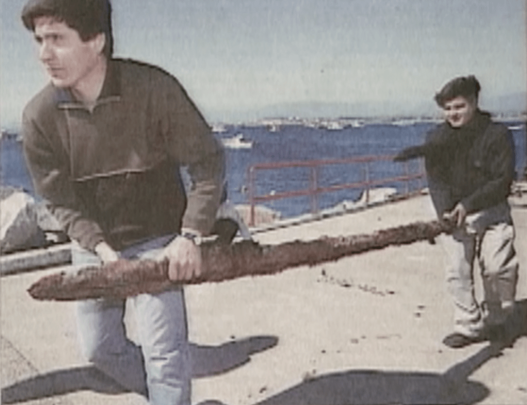 Detectives carry a piece of rail found by divers at Quintero Bay. 