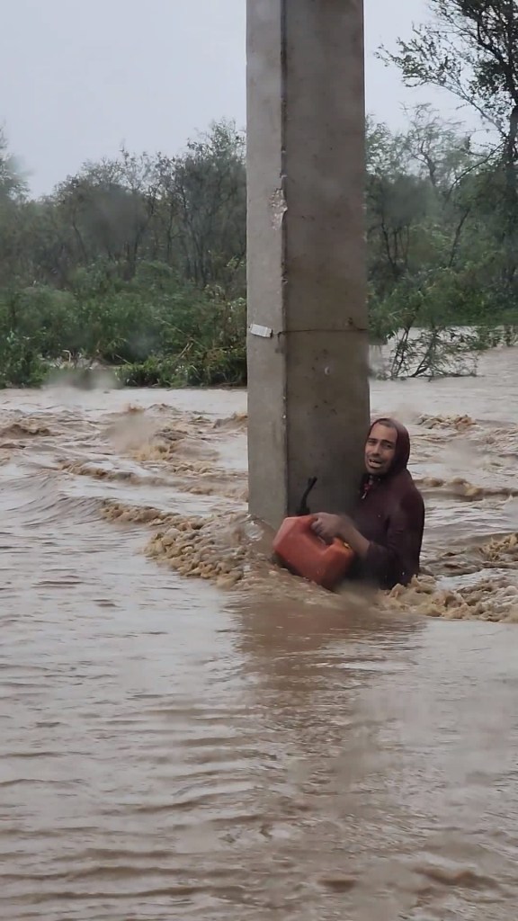 A man clings to a pillar during flooding caused by Hurricane Fiona in 2022.