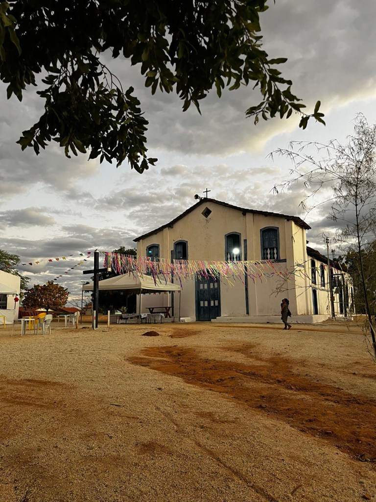 A small church building which opens onto an unpaved public plaza.