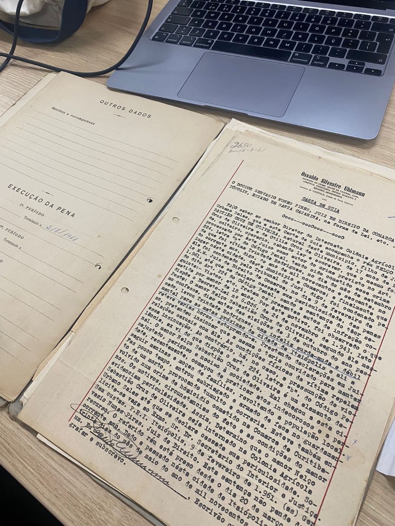 A binder of legal documents that form a prisoner's file sits on a table.